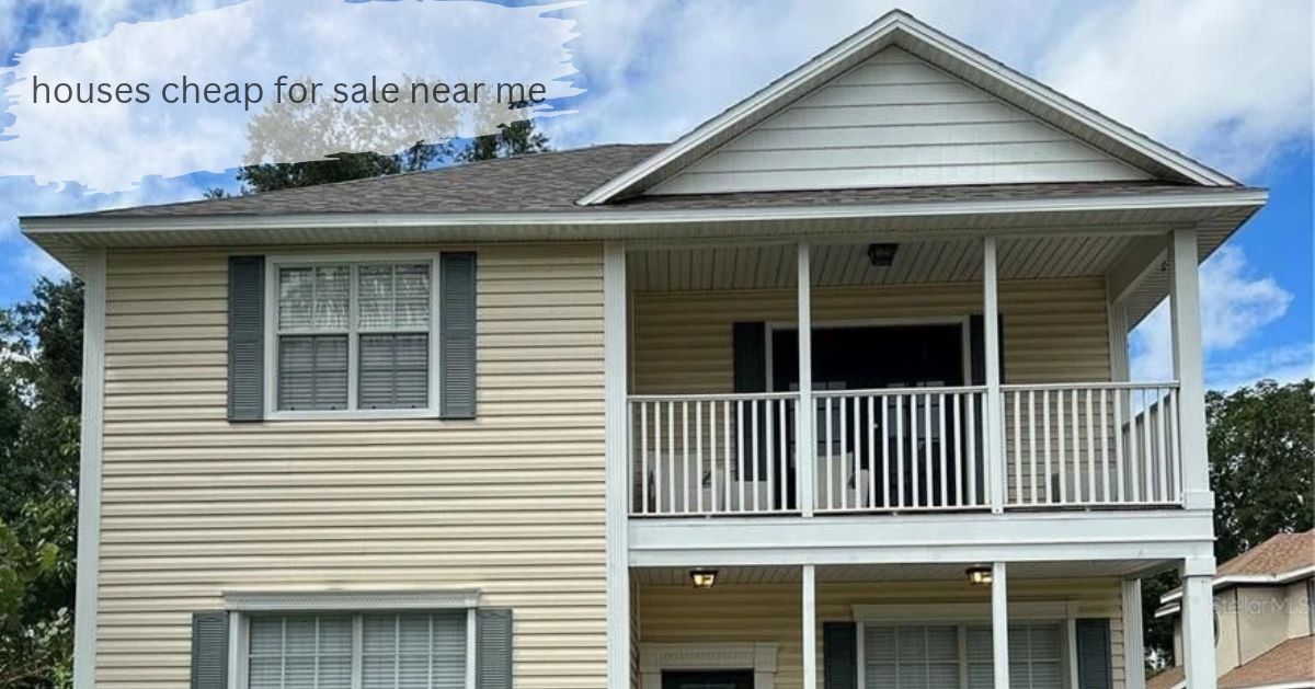 Two story cream vinyl-sided house with gray shutters and a second-floor balcony with white railings, houses cheap for sale near me