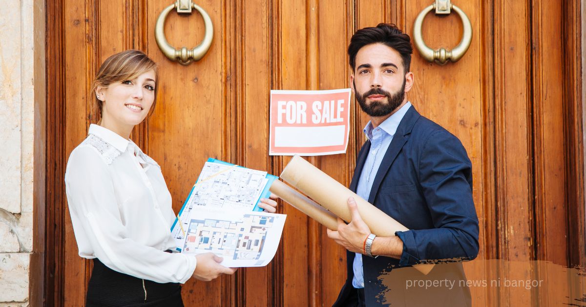 Two property agents holding floor plans beside a “For Sale” sign on a wooden door, Property News NI Bangor