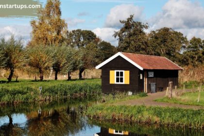Cozy wooden cabin beside a calm creek surrounded by lush green wetlands and autumn trees in Findlay Creek, Ottawa
