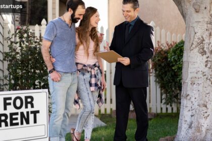 A real estate agent in a dark suit reviewing a rental application on a clipboard with a young couple on a grassy lawn next to a white picket fence and a prominent "FOR RENT" yard sign, demonstrating the process of finding houses to rent in near me.