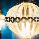 Close up of vintage globe light bulbs with decorative black metal trim glowing with warm yellow light