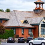 A beautiful Regina estate home with a multi-tiered slate roof, copper accents, and a distinctive clock tower, showcasing premium listings available on the MLS Regina market.