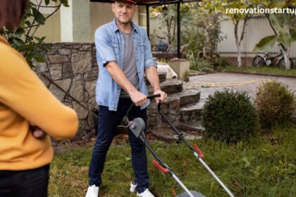 Man mowing backyard lawn with woman watching during backyard renovation