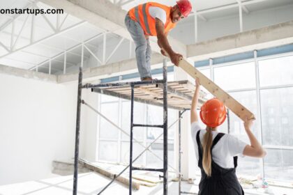 Commercial renovation contractors working on scaffolding in an office space with wood plank and hard hats.