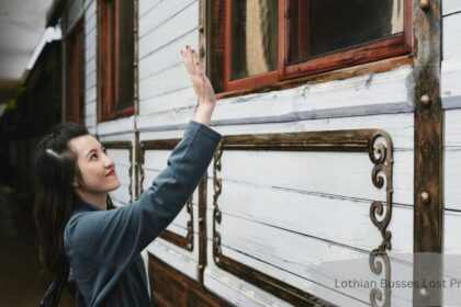 Woman reaching toward vintage train carriage window while searching for Lothian Busses Lost Property items
