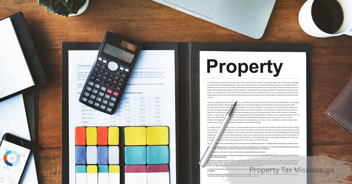 Flat-lay desk view featuring a calculator resting on financial documents, colorful index cards, a pen resting on a page titled "Property", and a coffee cup on a wooden table.