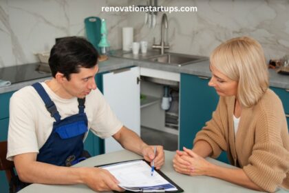 Contractor and homeowner discussing kitchen renovation cost estimate on a clipboard in a modern kitchen with teal cabinets