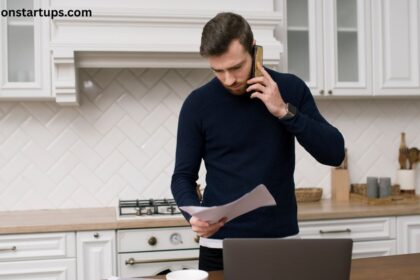 Man reviewing renovation quote on phone in white kitchen — kitchen renovation cost Toronto