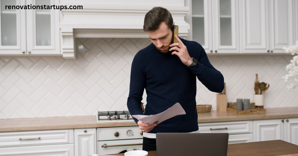 Man reviewing renovation quote on phone in white kitchen — kitchen renovation cost Toronto