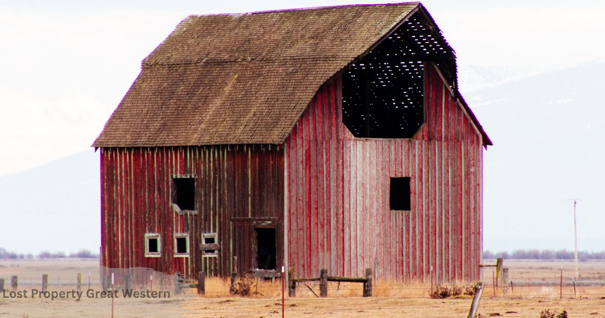 Weathered red barn with a partially collapsed roof standing in an open field Lost Property Great Western