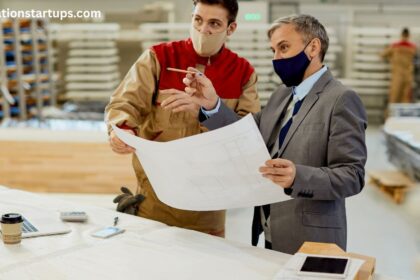 Contractor and homeowner reviewing blueprints together while discussing basement renovation financing options and project plans