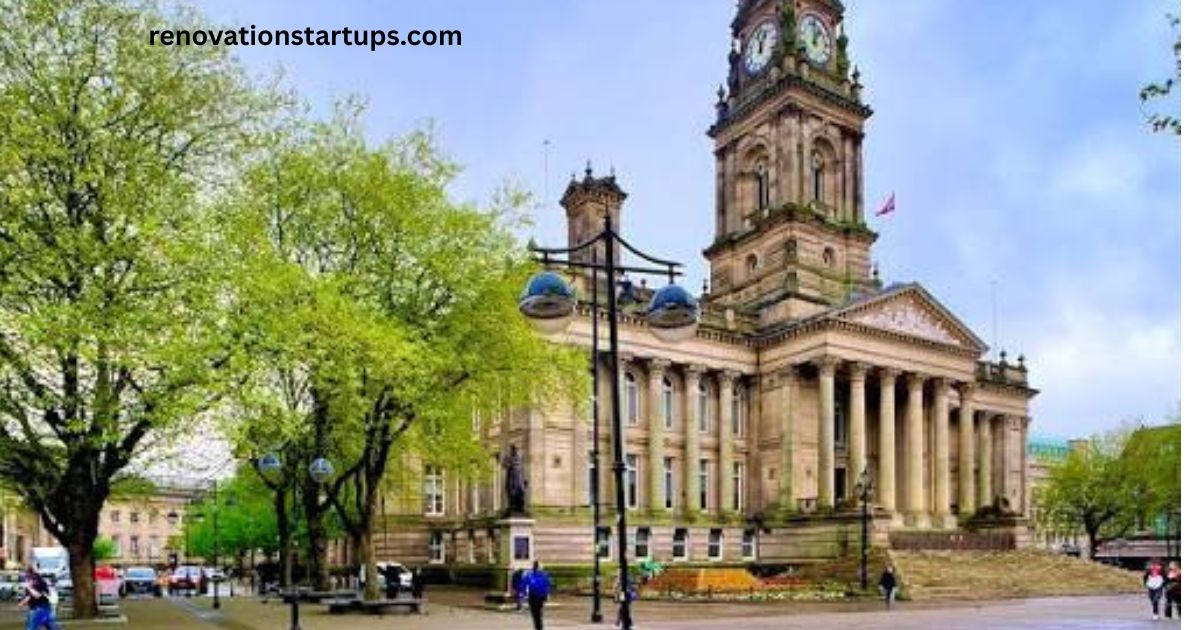Bolton Town Hall clock tower and columned portico with tree-lined square in spring