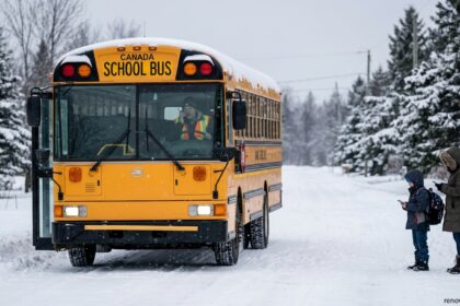 Canadian school bus on a snow-covered road highlighting school bus cancellations during winter weather.