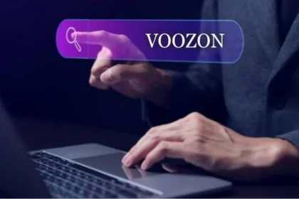 Person typing on laptop with a glowing search bar showing "VOOZON" and a magnifying glass icon, representing a voozon.com search
