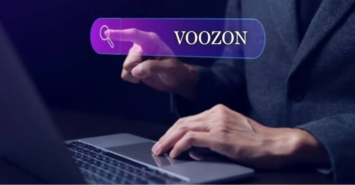 Person typing on laptop with a glowing search bar showing "VOOZON" and a magnifying glass icon, representing a voozon.com search
