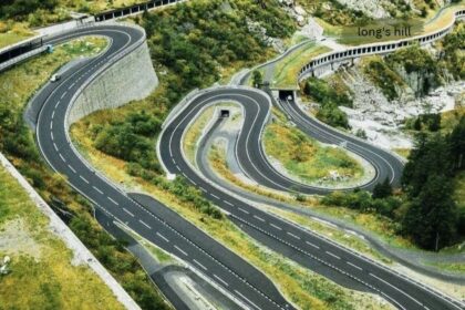 Winding mountain road with sharp hairpin bends curving down a green hillside, labeled Long's Hill
