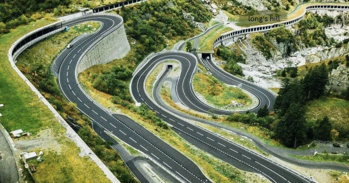 Winding mountain road with sharp hairpin bends curving down a green hillside, labeled Long's Hill