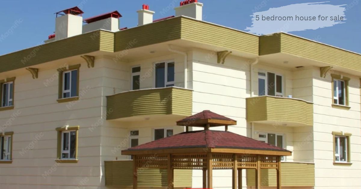 Exterior view of a modern multi-story residential building with light-colored siding and brown window frames. '5 bedroom house for sale'