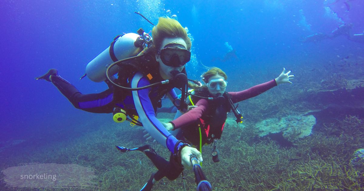 Two divers exploring a coral reef underwater with scuba gear during a snorkeling and diving trip
