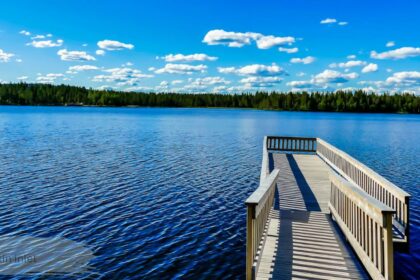 Rankin Inlet waterfront dock overlooking calm blue lake surrounded by forest