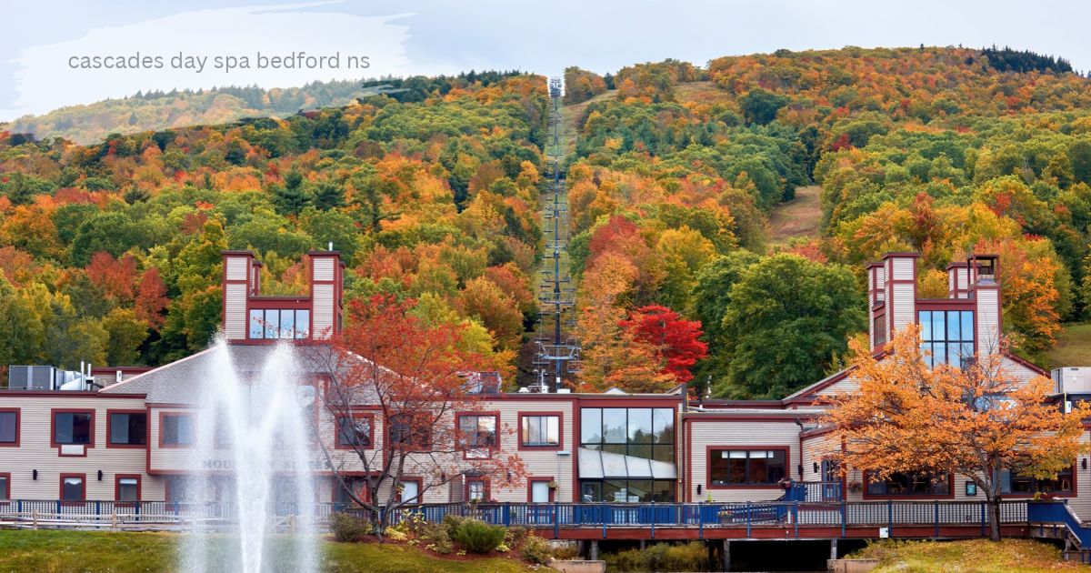 Scenic resort building with red trim and a large water fountain in front, set against a hillside with vibrant autumn trees and a ski lift.'cascades day spa bedford ns'