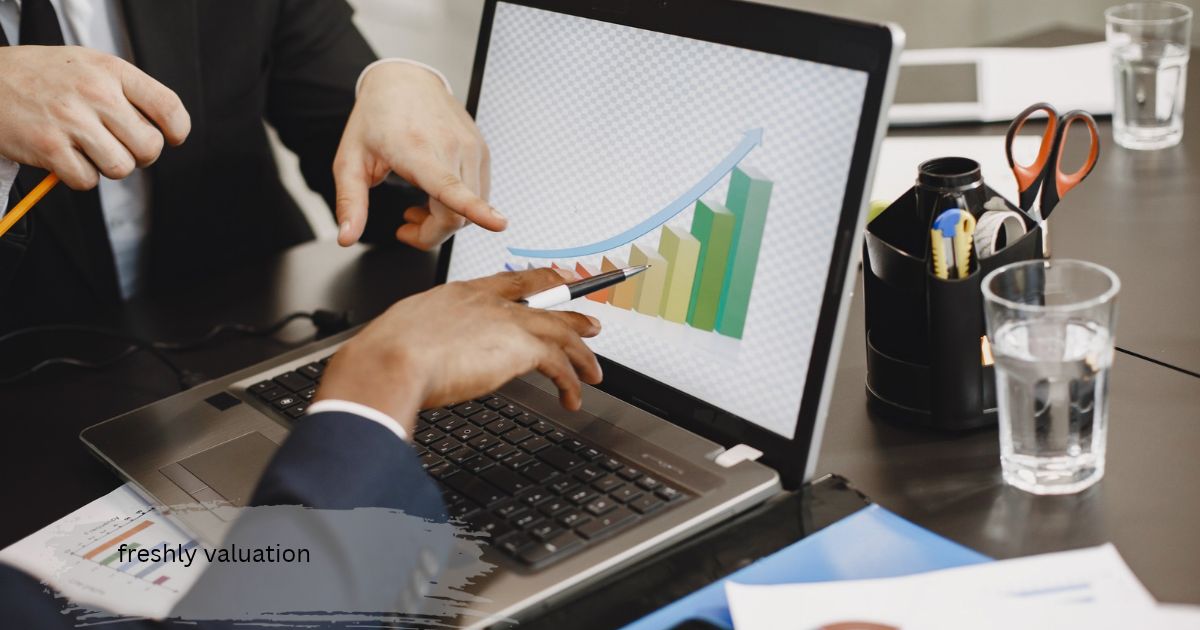 freshly valuation chart on a laptop screen as business colleagues point at a rising green bar graph during a meeting