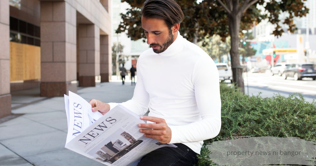 Man in a white turtleneck reading a “News” newspaper on a city street, Property News NI Bangor